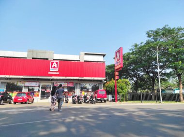 Ciledig, Endonezya - 15 Eylül 2024: Cesur kırmızı dış görünüşlü bir Alfamidi marketinin parlak ve net bir görüntüsü. Birçok motosiklet ve araba mağazanın önünde park edilmiştir.