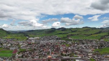 Yeşil tepeleri ve arka planda küçük bir köyü olan küçük bir köyün güzel manzarası.