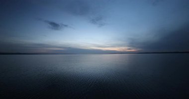 Sakin göl üzerinde bulutlarla koyu mavi gökyüzü 8k ultra HD 