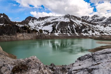 Arka planda dağlar olan göl