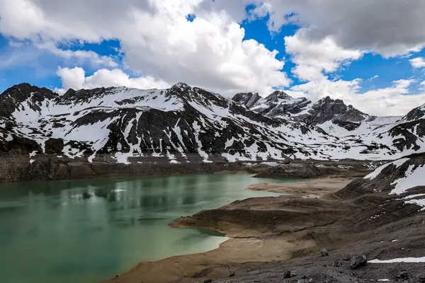 Karlı dağ manzarası - tepeli dağlar ve göl.