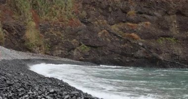 Madeira adasının kumsalında siyah kum. 8k ultra HD. 