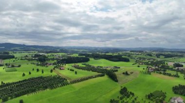 Ülkenin ortasında küçük bir köyle yeşil bir çayırın insansız hava aracı görüntüsü..