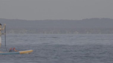 young man with paddle board in the water