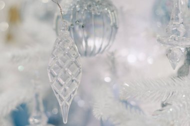 Akıp duran beyaz bir ağaçtır o. Süs, piramit şeklindedir. Ağaçta başka süsler de var.