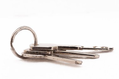 Üç anahtar bir anahtarlıkta asılı. Anahtarlar gümüş ve ortasında küçük bir delik var.