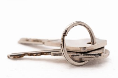 Üç anahtar bir anahtarlıkta asılı. Anahtarlar gümüş ve ortasında küçük bir delik var.