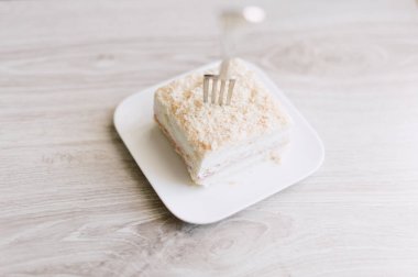 Bir çatal bir dilim kekle birlikte bir tabağın üzerindedir. Çatal gümüş.