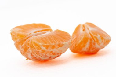 Küçük bir portakal ikiye bölünür. Turuncu mandalinanın içi ve dışı beyazdır.