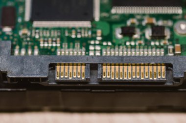 Altın uçlu siyah ve altın bir kablo siyah ve altın bir cihaza bağlıdır. Kablo uzun ve incedir ve muhtemelen cihazı bir güç kaynağına bağlamak ya da veri aktarmak için kullanılır.