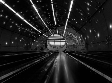 Tavanda ışıklar olan bir tünel. Tünel karanlık. Tünelde bir tren var. Polonya, Varşova 23.12.2024