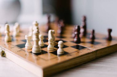 Üzerinde birkaç parça olan tahta bir satranç tahtası. Tahta bir satranç oyunu için kurulmuş.