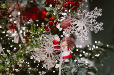 Üstünde kar tanesi süsü asılı bir Noel ağacı. Kar taneleri kırmızı ve beyaz bir dizaynla çevrilidir..