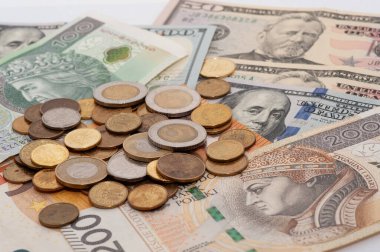 50 dolarlık banknot dahil bir yığın bozuk para ve banknot. Bozukluklar çeşitli boyut ve renklerde.