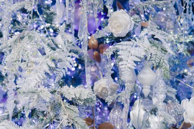 Mavi arkaplanın ortasında beyaz bir çiçek var. Çiçek mavi ve beyaz bir ağaçla çevrilidir.