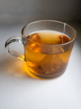 İçinde çay poşeti olan bir fincan çay. Çay sıcak ve bardak berrak.