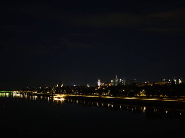 Varşova silueti geceleri ışıldıyor, ortasından bir nehir akıyor. Varşova, Polonya 01.06.2024