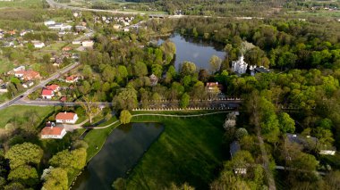 Arka planda bir göleti ve kilisesi olan güzel yeşil bir tarla. Sahne huzurlu ve huzurlu. Hava fotoğrafçılığı
