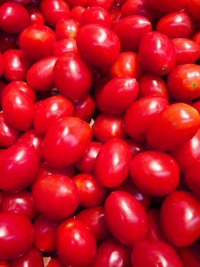 Bir avuç kırmızı domates. Hepsi aynı boyutta. Çok kalabalıklar.