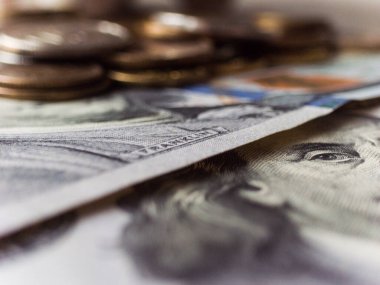 Üzerinde Franklin 'in yazılı olduğu bir yığın Amerikan doları. Yığın, başka bir Amerikan para biriminin üzerine konur.