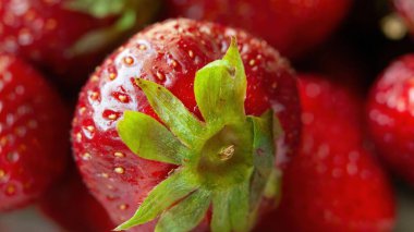 Üzerinde yeşil yaprak olan kırmızı bir çileğe yaklaş. Tazelik ve doğal güzellik kavramı