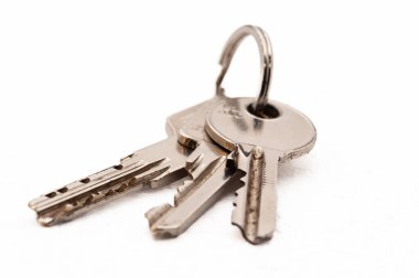 Üç anahtar bir anahtarlıkta asılı. Anahtarlar gümüş ve ortasında küçük bir delik var.