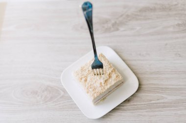 Bir çatal bir dilim kekle birlikte bir tabağın üzerindedir. Çatal gümüş.