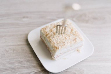 Bir çatal bir dilim kekle birlikte bir tabağın üzerindedir. Çatal gümüş.