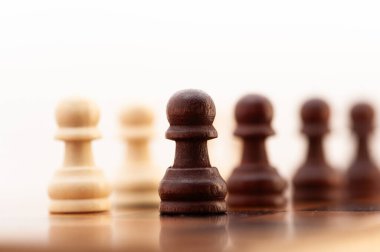 Siyah beyaz bir satranç taşı diğer taşlarla birlikte tahtada duruyor. O bir piyon, tahtanın en küçük ve en az güçlü parçası. Piyon tahtanın ortasına yerleştirildi.