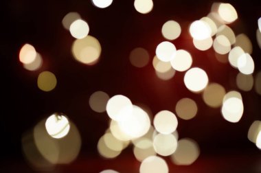 Birçok beyaz daireli kırmızı arkaplanın bulanık bir görüntüsü. Daireler farklı boyutlarda ve görüntüye dağılmış durumda. Sahne kaos ve karmaşadır.