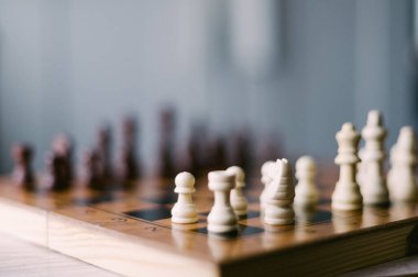 Üzerinde taşlar olan bir satranç tahtası. Tahta siyah beyaz. Parçalar bir oyun oynamaya hazır bir şekilde düzenlenir.