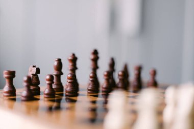 Üzerinde taşlar olan bir satranç tahtası. Tahta siyah beyaz. Parçalar bir oyun oynamaya hazır bir şekilde düzenlenir.