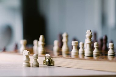 Üzerinde birkaç parça olan tahta bir satranç tahtası. Tahta bir satranç oyunu için kurulmuş.