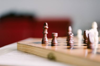 Üzerinde birkaç parça olan tahta bir satranç tahtası. Tahta bir satranç oyunu için kurulmuş.