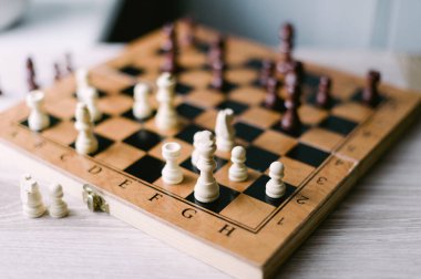 Üzerinde birkaç parça olan tahta bir satranç tahtası. Tahta bir satranç oyunu için kurulmuş.