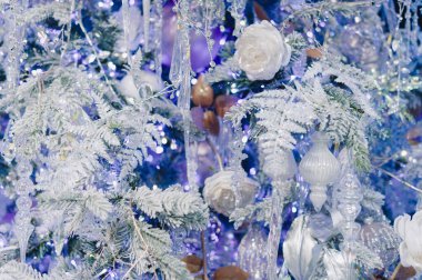 Mavi arkaplanın ortasında beyaz bir çiçek var. Çiçek mavi ve beyaz bir ağaçla çevrilidir.