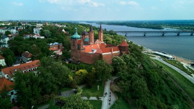 Vistula Nehri üzerinde tarihi bir Polonya şehri olan Plock 'un manzaralı manzarası. Görüntü, kırmızı çatıları ve kuleleri olan Kutsal Bakire Meryem 'in Varsayımının Katedral Bazilikası' nı yansıtıyor.