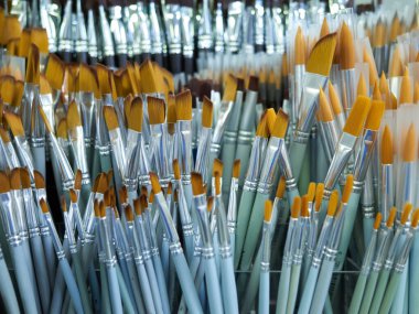 Çeşitli boylarda ve renklerde büyük bir boya fırçası koleksiyonu. Bazıları mavi, bazıları yeşil, ve bazıları sarı.