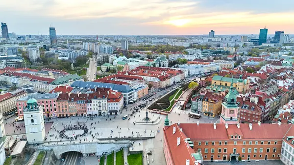 Varşova manzarası. Eski şehrin ortasında büyük bir kalabalık var. Gökyüzü turuncu ve güneş batıyor. İHA görüntüsü. Varşova 13.04.2025, Polonya