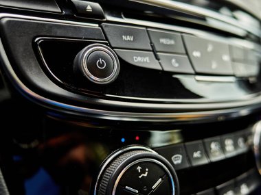 Müzik, ses ve diğer ayarlar için düğmeleri olan araba radyosu. Düğmeler siyah ve radyo siyah.