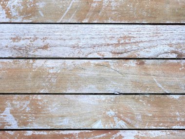 Üzerinde bir sürü boya ve çizik olan ahşap bir yüzey. Ahşap eskimiş ve yıpranmış gibi görünüyor. Bu da kırsal ya da klasik hissi uyandırıyor.