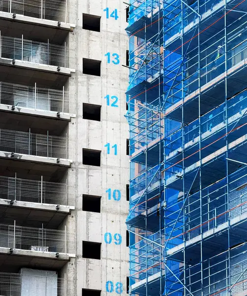 Brentford, Batı Londra 'da inşa halinde olan yeni bir apartman dairesi. Beton yapıda zemin numaraları işaretli ve mavi iskele var.