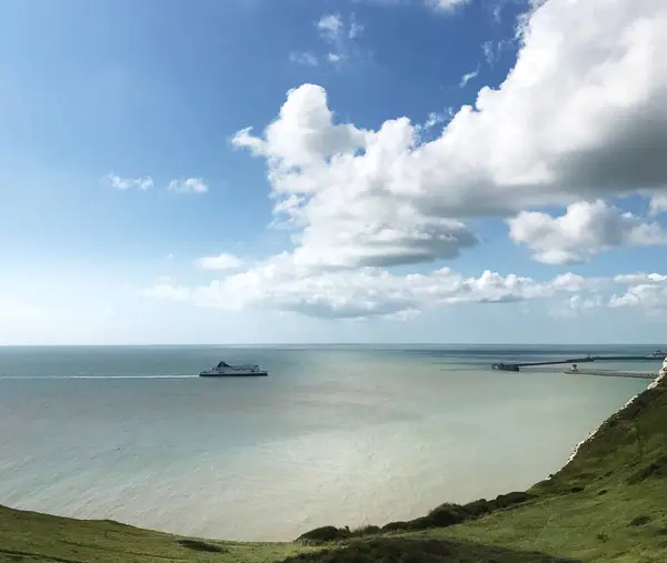 Dover 'ın Beyaz Uçurumları' ndan İngiliz Kanalı 'nın görüntüsü, Dover Limanı' na yaklaşan bir feribotla. Deniz düz ve sakin, güneşli bir gün..