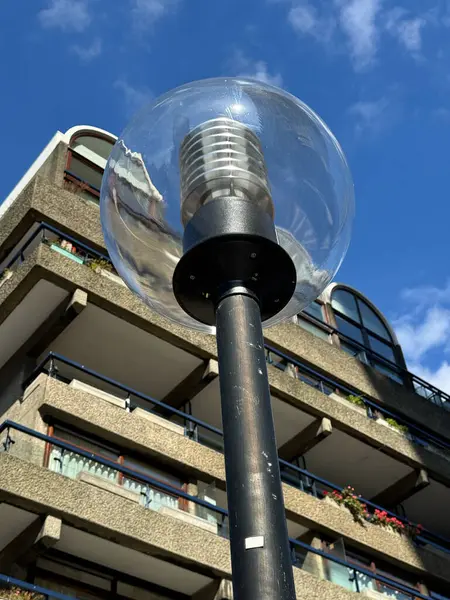 Barbican, Londra 'da bir sokak lambası. Arkasında Londra 'nın beton modernist şehrinin balkonları var..