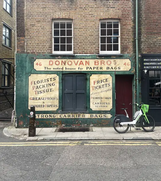 Spitalfields, Londra 'da eski bir dükkanın önüne park edilmiş bir limon bisikleti.. 
