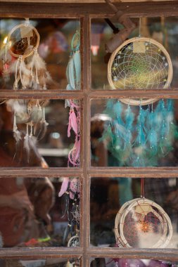 Dreamcatcher hanging on the window at sunset - reflection in the window. Various dream catchers. clipart