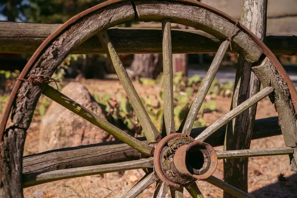 stock image Old western wagon wheel. Close-up of a weathered wagon wheel in a desert landscape.