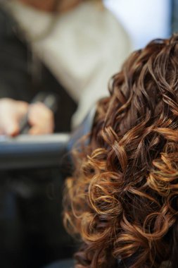 Güzellik salonunda güzel bir kızın bukleleri. Profesyonel bir kuaförün çalışmasının sonucu. kıvırcık kız metodu, doğal güzellik saçı, CGM