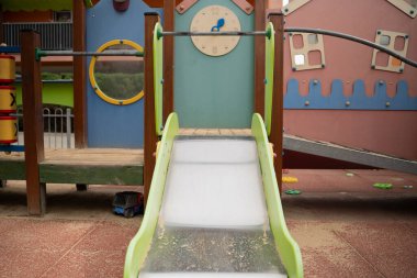 Ahşaptan yapılmış boş çocuk parkı, renkli, kaydıraklı, saat evi. Güneşli yaz günü.