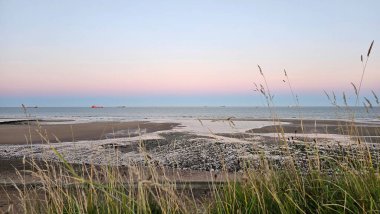 Colourful moonrise over North Sea in Scotland, Aberdeen. Foreground green grass. High quality photo clipart